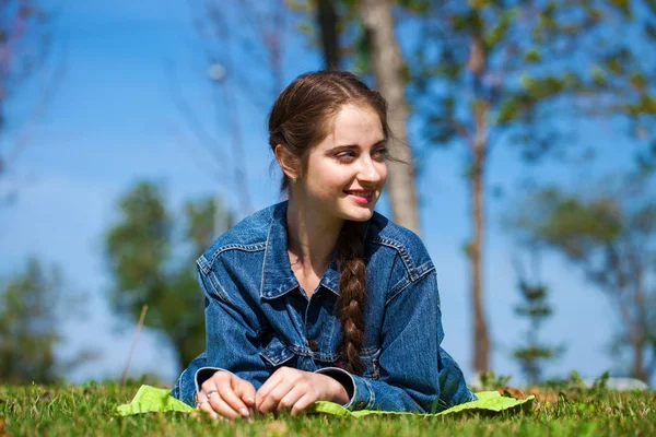 Yeşil çimenler üzerinde yatan güzel genç esmer kadın — Stok fotoğraf