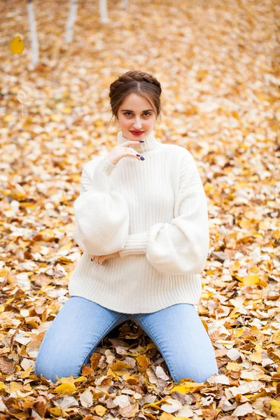 Young beautiful girl in blue jeans and gwhite sweater — Stock Photo, Image