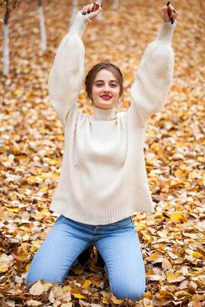 Young beautiful girl in blue jeans and gwhite sweater — Stock Photo, Image