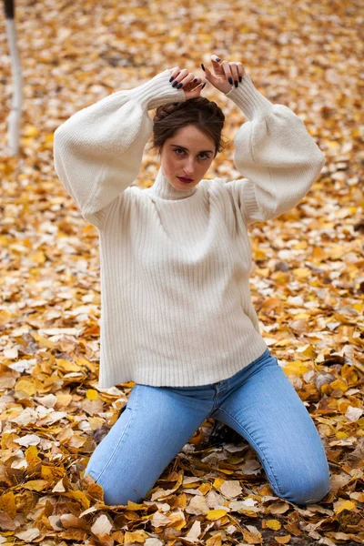 Jong mooi meisje in blauw jeans en wit trui — Stockfoto