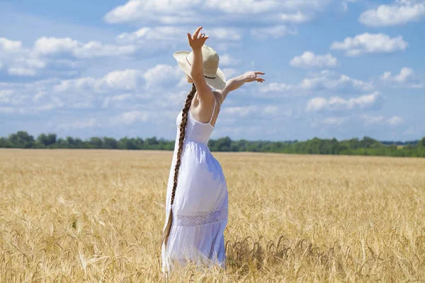 흰색 드레스를 입은 젊은 여성이 푸른 하늘을 배경으로 포즈를 취하고 있다. — 스톡 사진