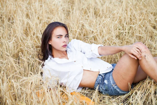 Young brunette woman in white shirt and blue jeans shorts — Stock Photo, Image