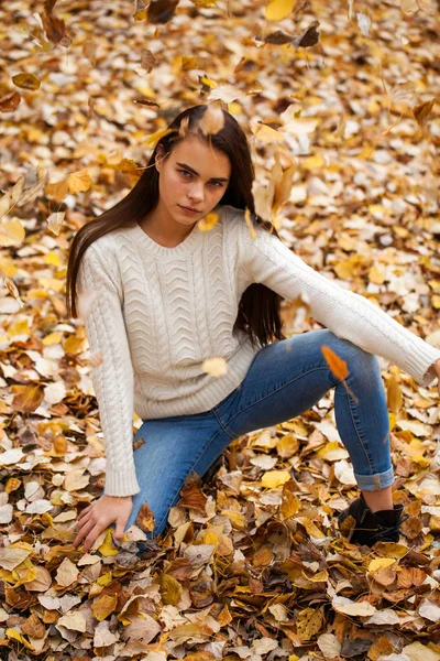 Young beautiful girl in blue jeans and gwhite sweater — Stock Photo, Image