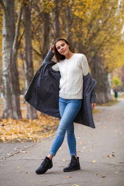 Portrait of a young beautiful girl in blue jeans and gray coat — Stock Photo, Image