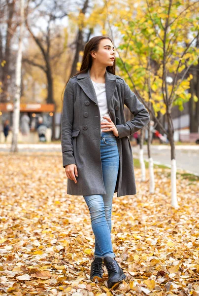 청바지와 회색 코트를 입은 아름다운 소녀의 사진 — 스톡 사진
