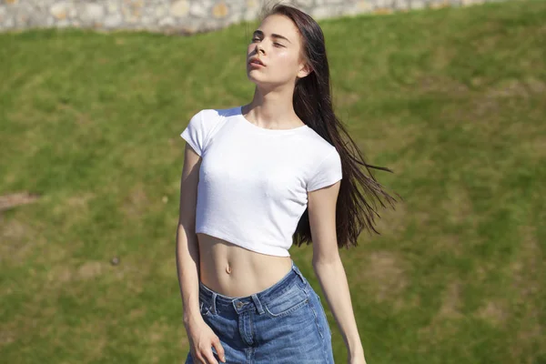 Jovem bela adolescente posando contra o parque de verão, brilhante — Fotografia de Stock