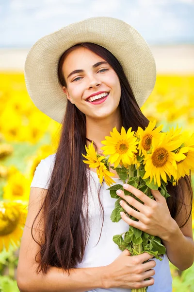 Retrato de uma jovem menina bonita em um campo de girassóis — Fotografia de Stock