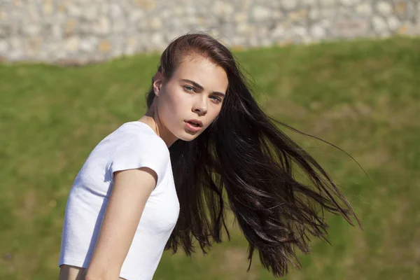 Yaz parkına karşı poz veren genç ve güzel bir kız. — Stok fotoğraf