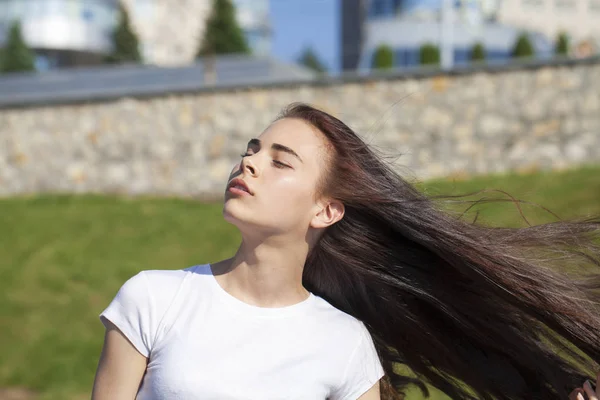 Yaz parkına karşı poz veren genç ve güzel bir kız. — Stok fotoğraf