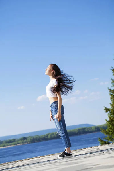 Beautiful brunette woman posing against blue sky bright sunny we — Stock Photo, Image