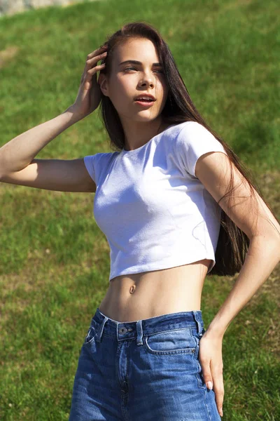 Young beautiful teenager girl posing against summer park, bright — Stock Photo, Image