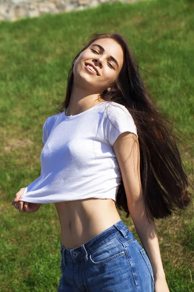 Joven hermosa adolescente posando contra el parque de verano, brillante —  Fotos de Stock