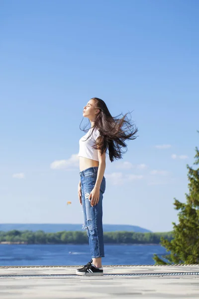 Hermosa mujer morena posando contra el cielo azul brillante soleado nosotros —  Fotos de Stock