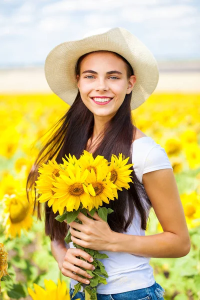 Retrato de uma jovem menina bonita em um campo de girassóis — Fotografia de Stock