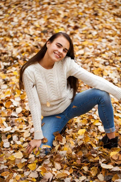 Young beautiful girl in blue jeans and gwhite sweater — Stock Photo, Image