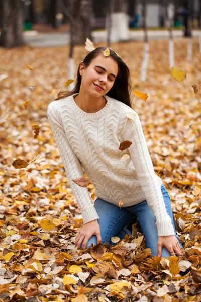 Young beautiful girl in blue jeans and gwhite sweater — Stock Photo, Image