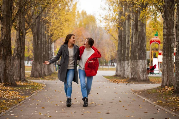 Zwei Freundinnen in grauem Wollmantel und roter Daunenjacke — Stockfoto