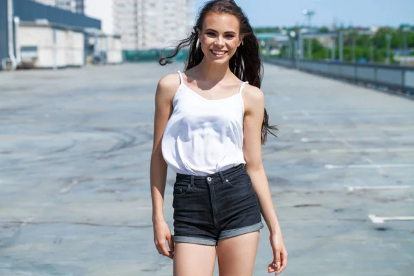 Hübsche junge brünette Modell in weißer Sommerbluse und Jeans, su — Stockfoto