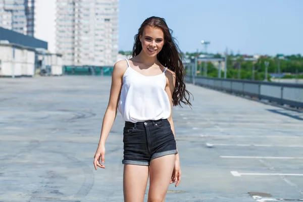 Hezká mladá brunetka, v bílé letní blůze a džínách, su — Stock fotografie