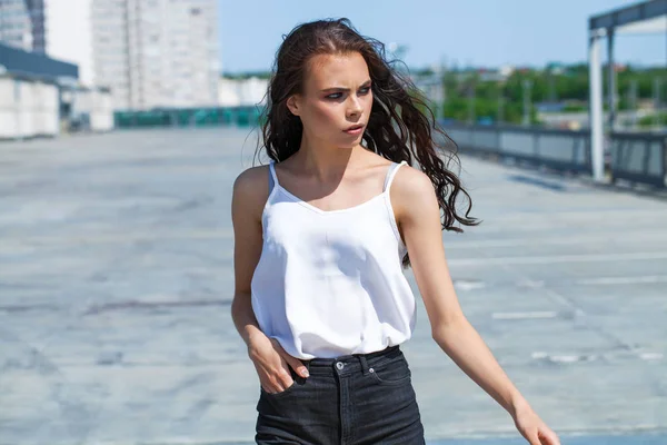 Całkiem młoda brunetka modelka w białej letniej bluzce i jeansach, SU — Zdjęcie stockowe