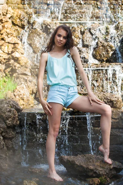 Jeune modèle brune en chemisier turquoise et short en jeans — Photo