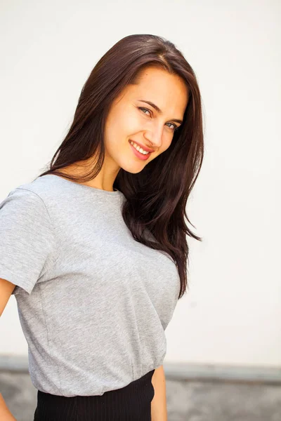 Happy brunetka kobieta w szarym t-shirt — Zdjęcie stockowe