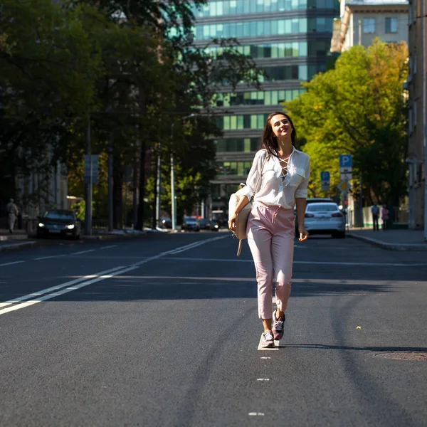 Junge schöne brünette Frau zu Fuß auf der Straße — Stockfoto