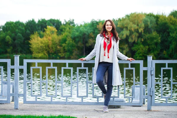 Porträtt av en ung vacker flicka i blå jeans och grå rock — Stockfoto