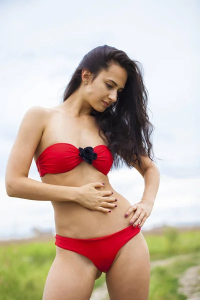 Happy young brunette woman in red bikini, summer outdoors — Stock Photo, Image