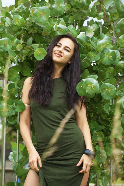 Porträtt av en ung vacker kvinna i grönt lövverk — Stockfoto