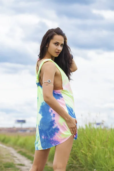 Young beautiful woman in colored tunic posing against the backgr — Stock Photo, Image