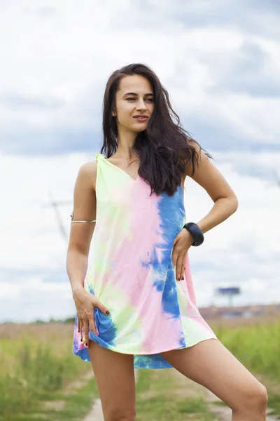 Young beautiful woman in colored tunic posing against the backgr — Stock Photo, Image