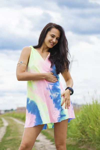 Young beautiful woman in colored tunic posing against the backgr — Stock Photo, Image