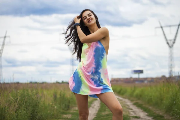 Young beautiful woman in colored tunic posing against the backgr — Stock Photo, Image