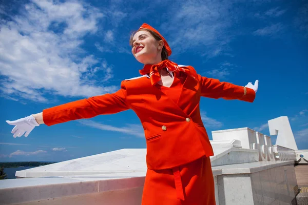 Hermosa azafata vestida con uniforme oficial rojo gjalá bl — Foto de Stock