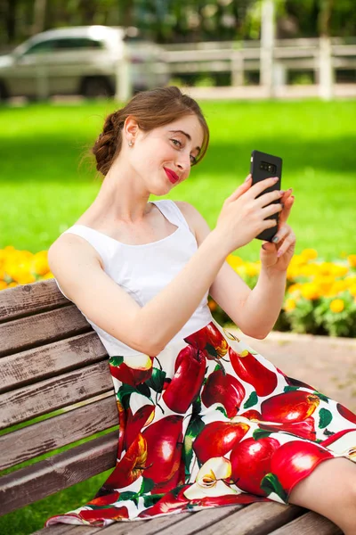 Junge brünette Frau liest eine Nachricht am Telefon — Stockfoto