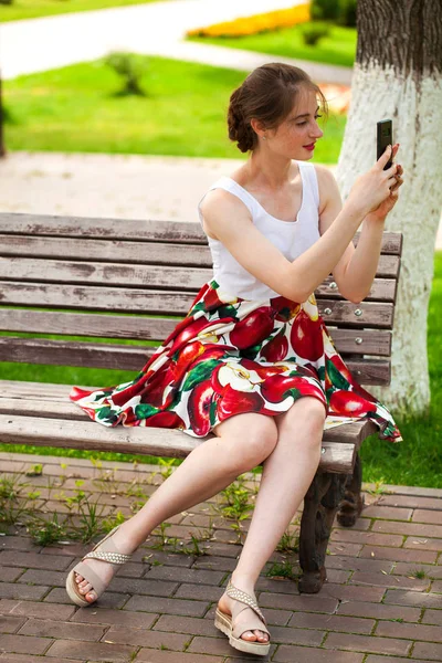 Young brunette woman reading a message on the phone — Stock Photo, Image