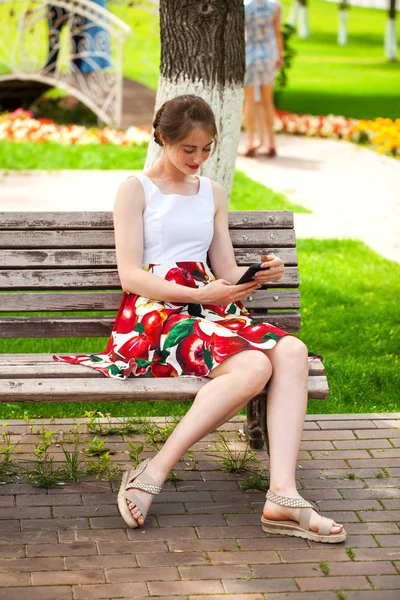 Молодая брюнетка читает сообщение по телефону — стоковое фото