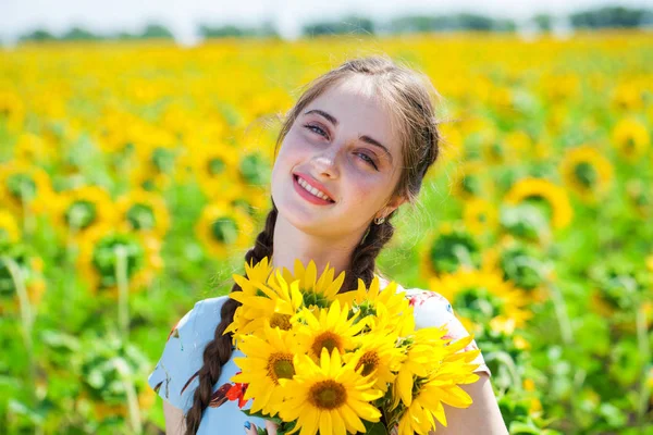 Portret młodej kobiety z bukietem kwiatów na polu o — Zdjęcie stockowe