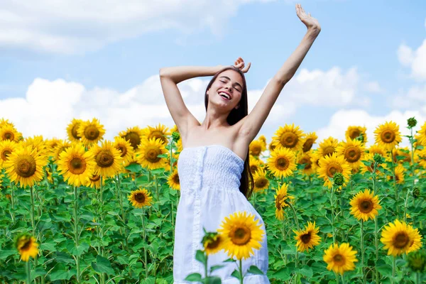 Ung vacker flicka i ett fält av solrosor fält — Stockfoto