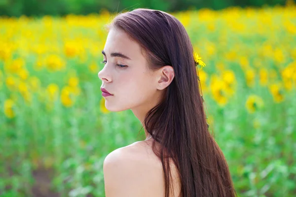 Junges schönes Mädchen in einem Feld von Sonnenblumen Feld — Stockfoto