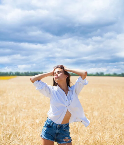 Giovane donna bruna in camicia bianca e pantaloncini jeans — Foto Stock