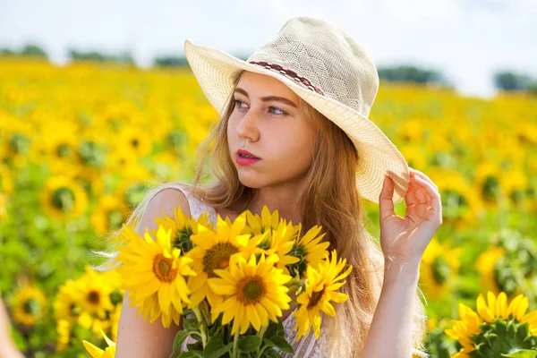 Retrato de uma jovem menina bonita em um campo de girassóis — Fotografia de Stock