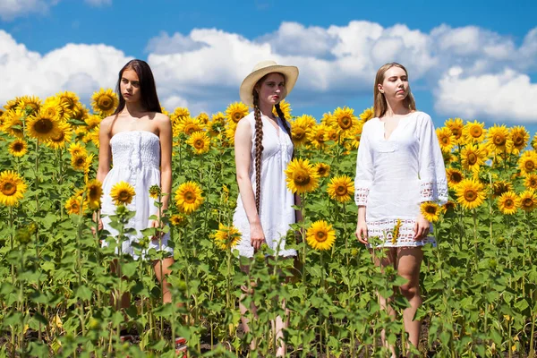 Drei junge Frauen in weißem Kleid posieren vor dem blauen Himmel in — Stockfoto