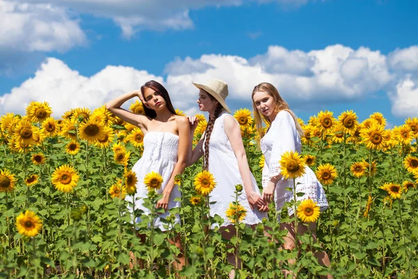 Drei junge Frauen in weißem Kleid posieren vor dem blauen Himmel in — Stockfoto