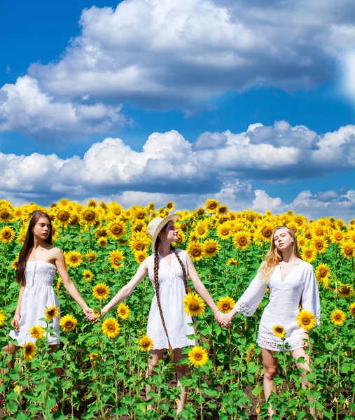 Drei junge Frauen in weißem Kleid posieren vor dem blauen Himmel in — Stockfoto