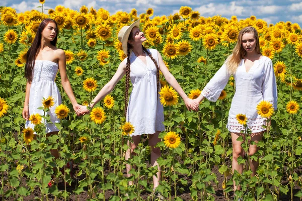 Tres mujeres jóvenes en vestido blanco posando contra el cielo azul en — Foto de Stock