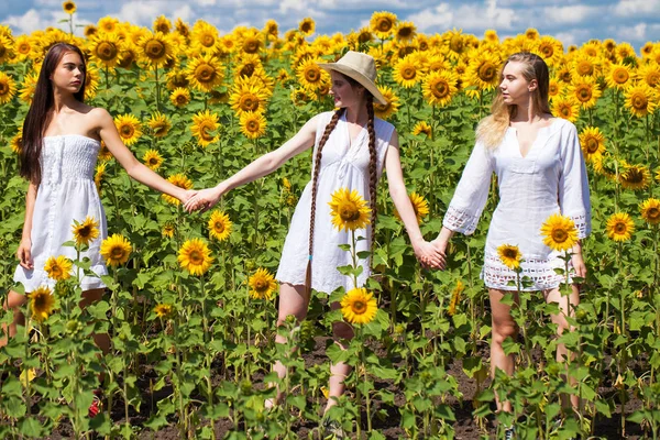 Tři mladé ženy v bílých šatech na modrém nebi v — Stock fotografie