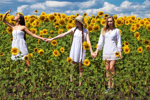 Três jovens mulheres de vestido branco posando contra o céu azul em — Fotografia de Stock