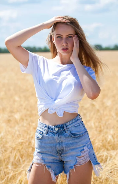 Молодая брюнетка в белой рубашке и джинсовых шортах — стоковое фото